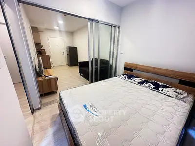 Modern bedroom with sliding glass doors and cozy living area in view