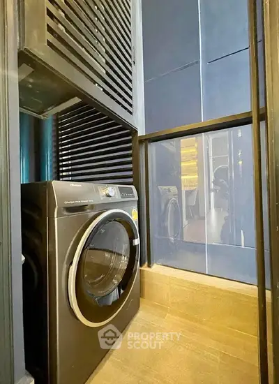 Modern laundry area with sleek washing machine in stylish apartment.