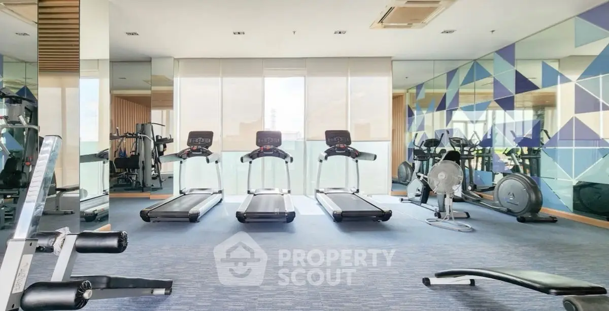 Modern gym with state-of-the-art equipment and stylish geometric wall design.