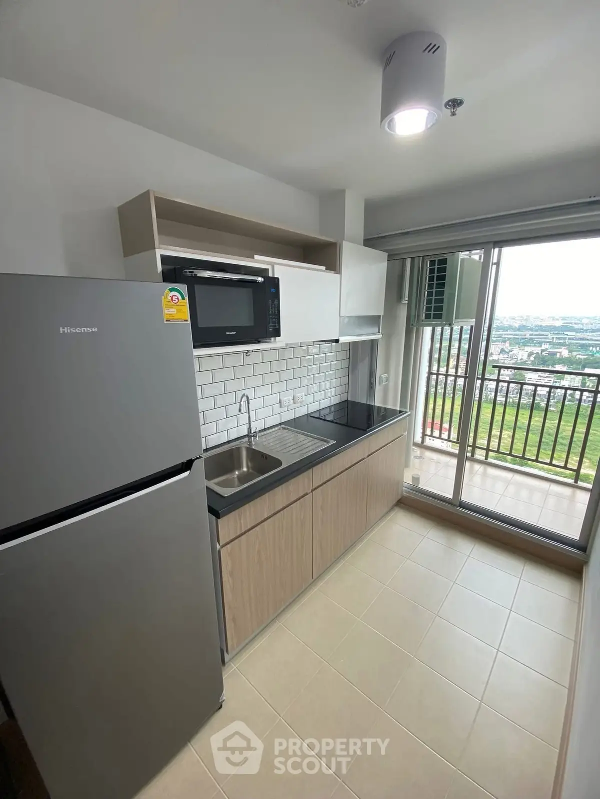 Modern kitchen with balcony view, featuring sleek appliances and stylish cabinetry.