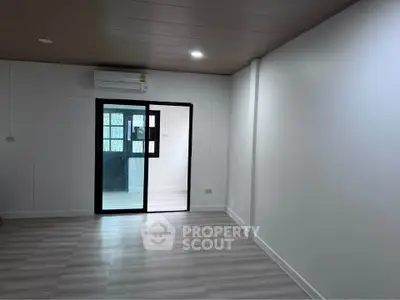 Spacious modern room with sleek flooring and air conditioning, perfect for versatile living arrangements.