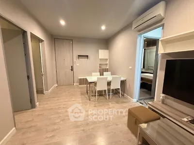 Modern living room with dining area and air conditioning, featuring sleek wooden flooring.