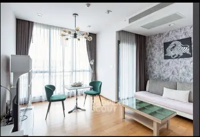 Modern living room with stylish decor, large windows, and elegant furniture in a bright apartment.