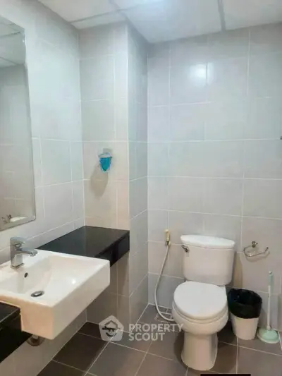 Modern bathroom with sleek fixtures and tiled walls in a contemporary apartment.