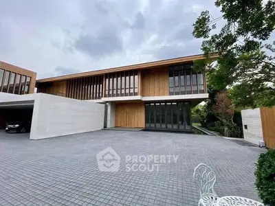 Luxurious modern home with expansive driveway and sleek architectural design.
