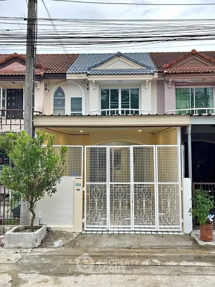 Charming townhouse with gated entrance and colorful facade in a cozy neighborhood.