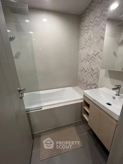 Modern bathroom with bathtub and stylish tile design, perfect for relaxation and comfort.