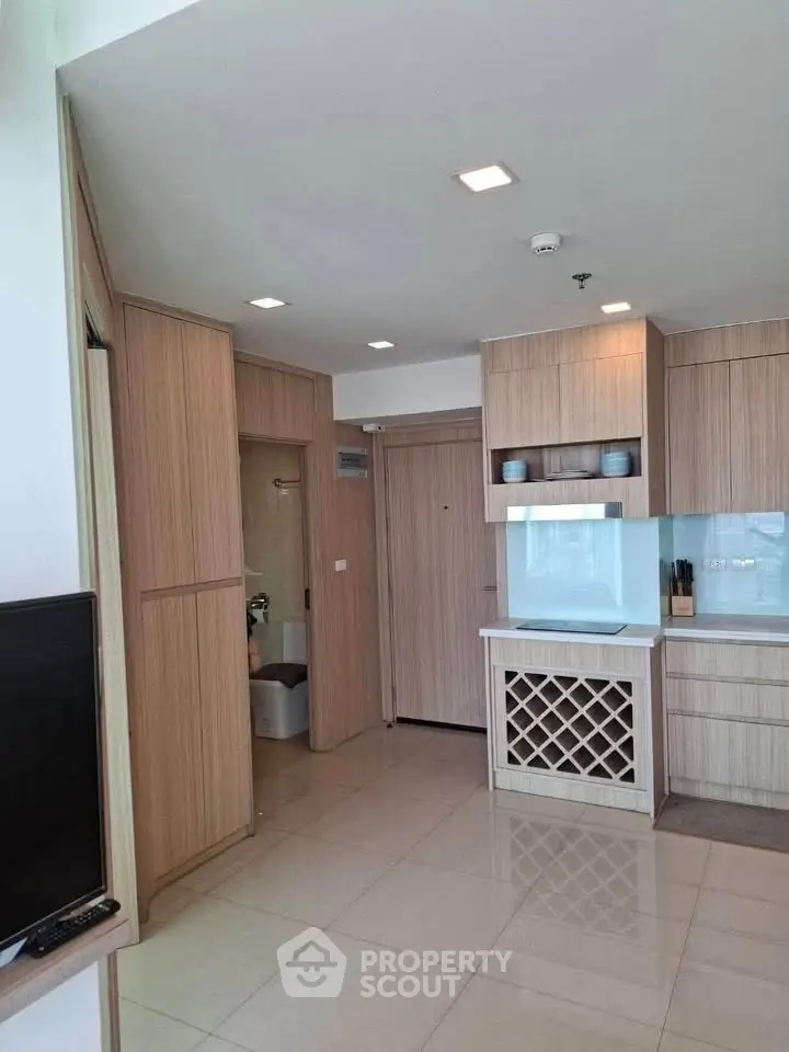 Modern kitchen with sleek cabinetry and wine rack in a stylish apartment.