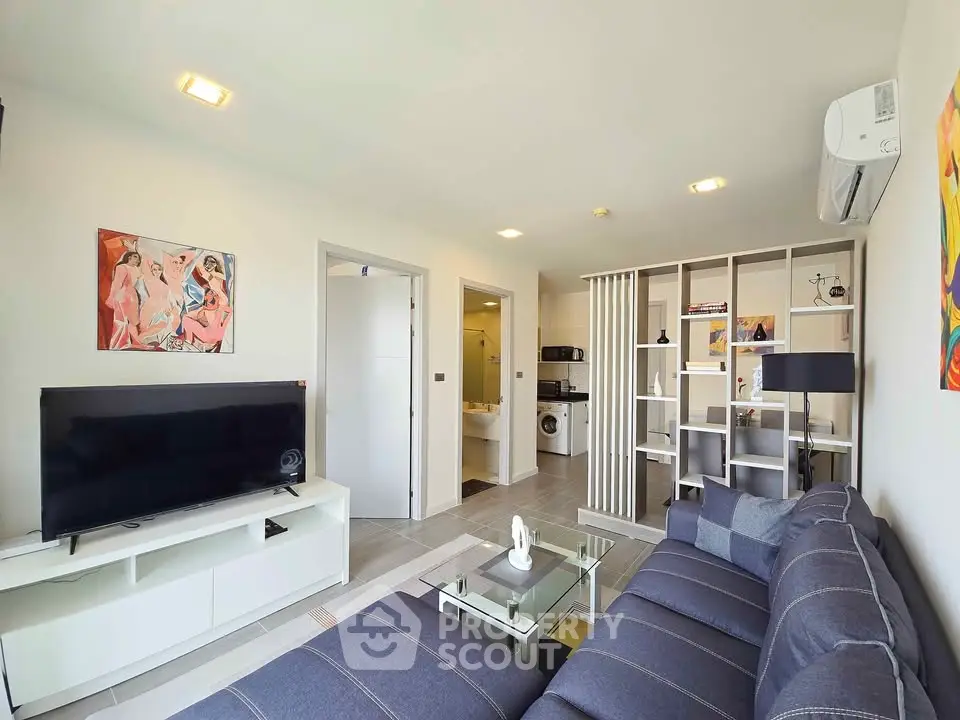 Modern living room with stylish decor and open layout, featuring a cozy sofa and entertainment center.