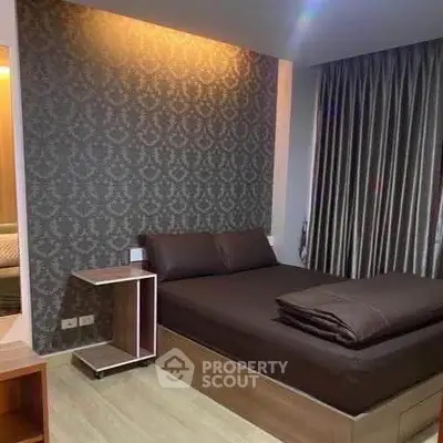 Modern bedroom with elegant wallpaper and cozy lighting in a stylish apartment.