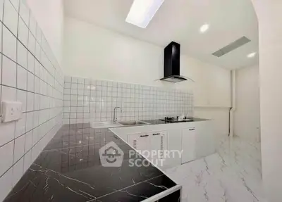 Modern kitchen with sleek black countertops and white tiled backsplash