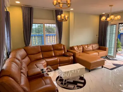 Spacious living room with modern leather sofas and elegant lighting, perfect for family gatherings.