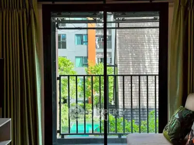 Charming apartment balcony view with lush greenery and modern building backdrop.
