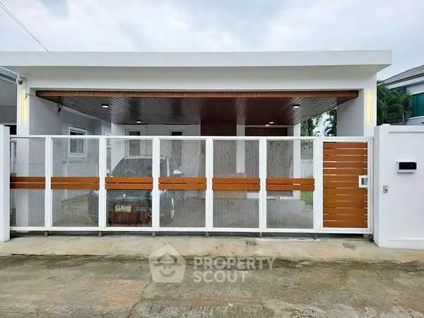 Modern single-story house with gated entrance and carport
