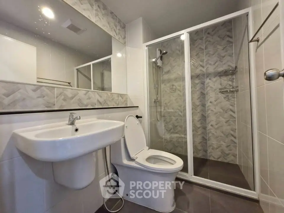 Modern bathroom with sleek shower and elegant fixtures in contemporary apartment.