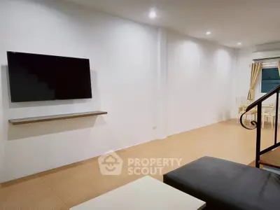 Spacious modern living room with wall-mounted TV and minimalist decor