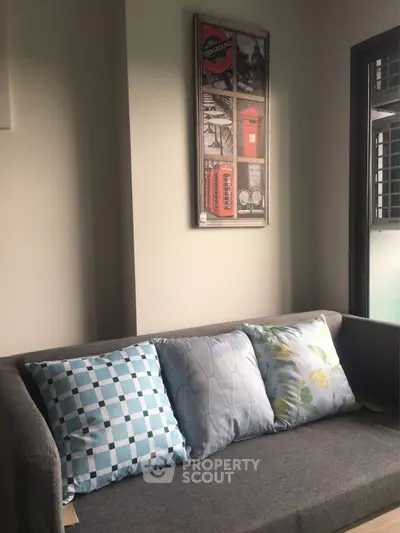 Stylish living room with modern gray sofa and decorative pillows, perfect for cozy relaxation.
