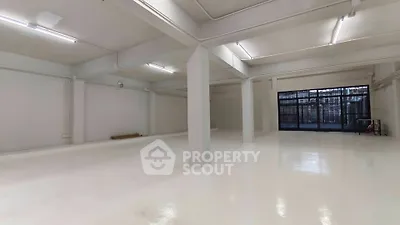 Spacious industrial-style open area with high ceilings and large windows