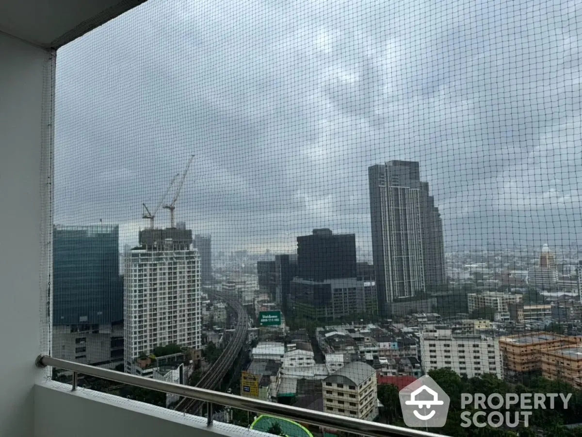 Stunning cityscape view from high-rise balcony with urban skyline and construction cranes.