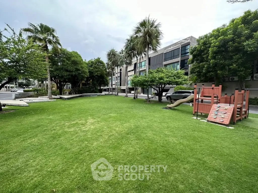 Spacious garden area with playground in modern residential complex.