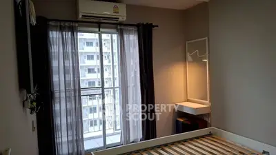 Modern bedroom with large window and city view, featuring sleek furniture and air conditioning.