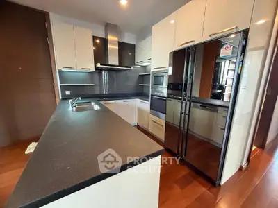 Modern kitchen with sleek cabinetry and stainless steel appliances in a luxury apartment.