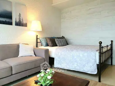 Cozy bedroom with stylish decor, featuring a comfortable bed and elegant sofa in a modern setting.
