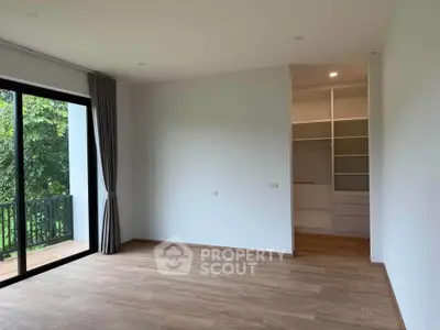 Spacious bedroom with walk-in closet and balcony view