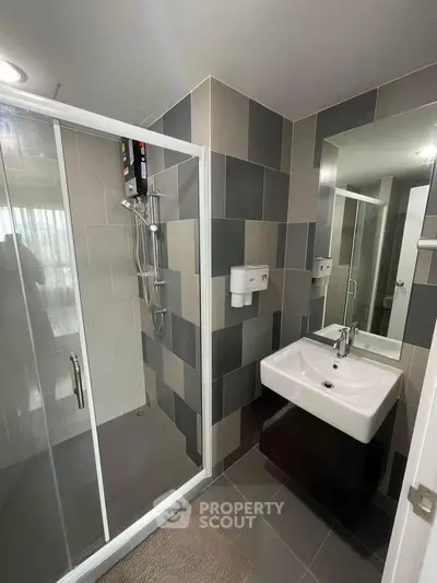 Modern bathroom with sleek shower and stylish sink in contemporary apartment.