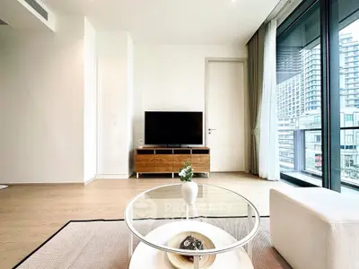 Modern living room with sleek design and large windows offering city views.
