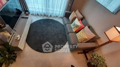 Stylish living room with cozy sofa, round rug, and modern decor in a bright apartment.