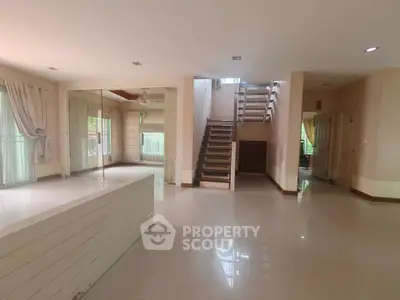 Spacious open-plan living area with modern staircase and large windows