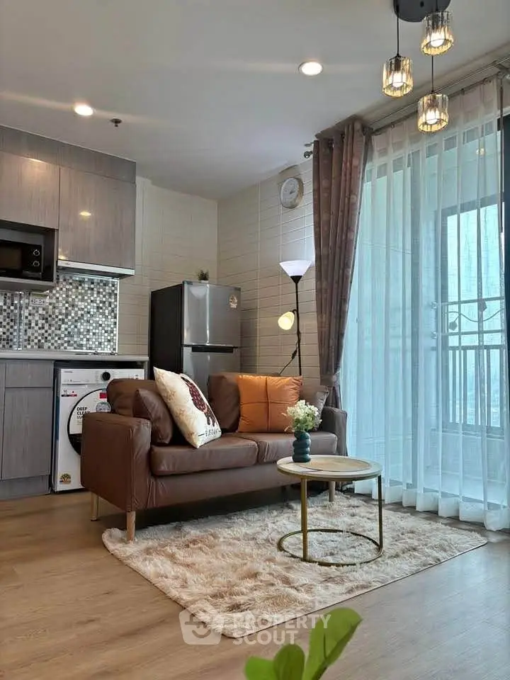 Modern living room with cozy sofa, stylish kitchen, and natural light from large windows.