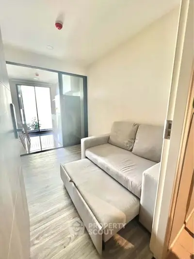 Cozy living room with modern sofa and natural light, perfect for relaxation and comfort.