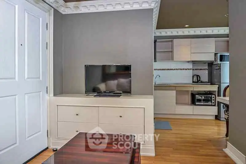 Modern apartment interior with sleek kitchen and cozy living area, featuring contemporary furniture and stylish decor.
