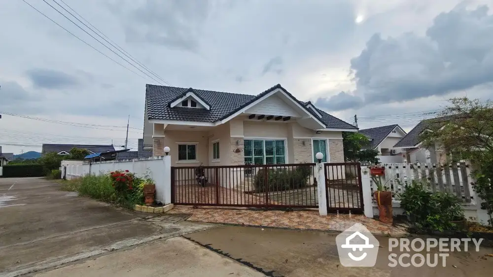 Charming single-story house with gated entrance and tiled front yard in a serene neighborhood.