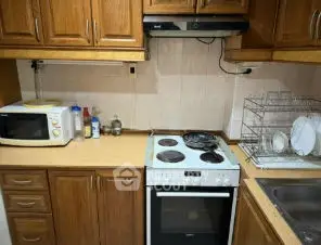 Cozy kitchen with wooden cabinets and modern appliances, perfect for culinary enthusiasts.