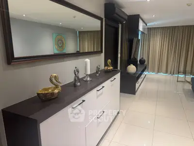 Modern living room with sleek decor and large mirror enhancing space.