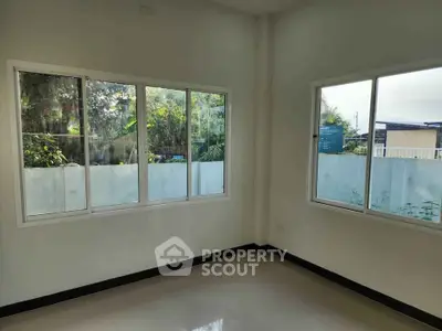 Bright empty room with large windows and garden view