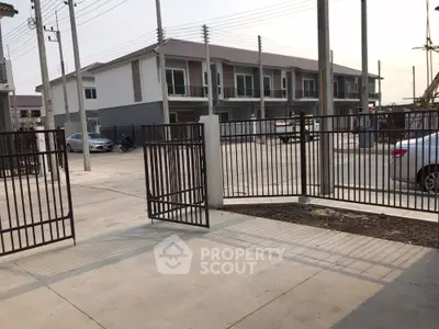 Modern townhouse complex with gated entrance and parking area