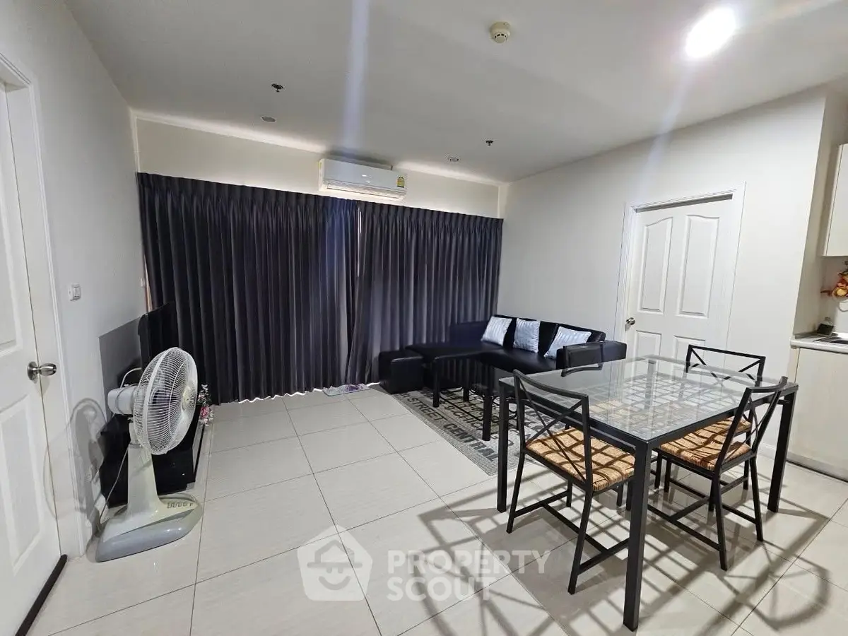 Spacious modern living room with sleek furniture and dining area, perfect for entertaining guests.