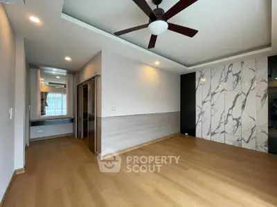 Spacious modern living room with wooden flooring and stylish ceiling fan