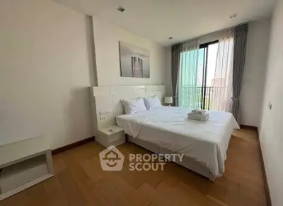 Spacious bedroom with modern decor and large window offering natural light.