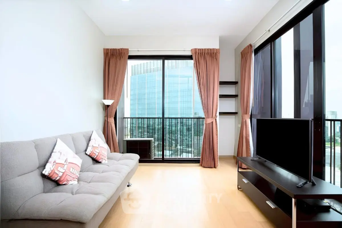 Modern living room with large windows and city view, featuring a stylish sofa and entertainment unit.