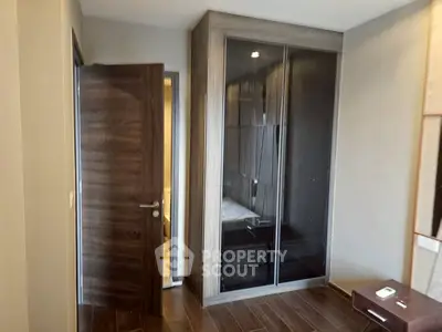 Modern bedroom with sleek wardrobe and wooden flooring