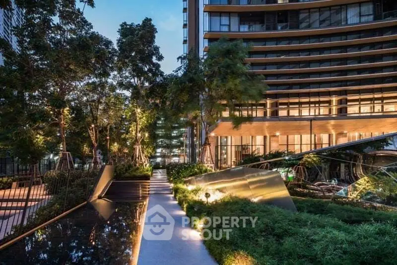 Luxurious modern building exterior with lush landscaped garden and elegant lighting at dusk.
