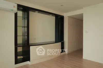 Spacious modern living room with built-in storage and sleek wooden flooring.