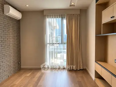 Modern empty room with wooden flooring, large window, and built-in shelves in a high-rise apartment.
