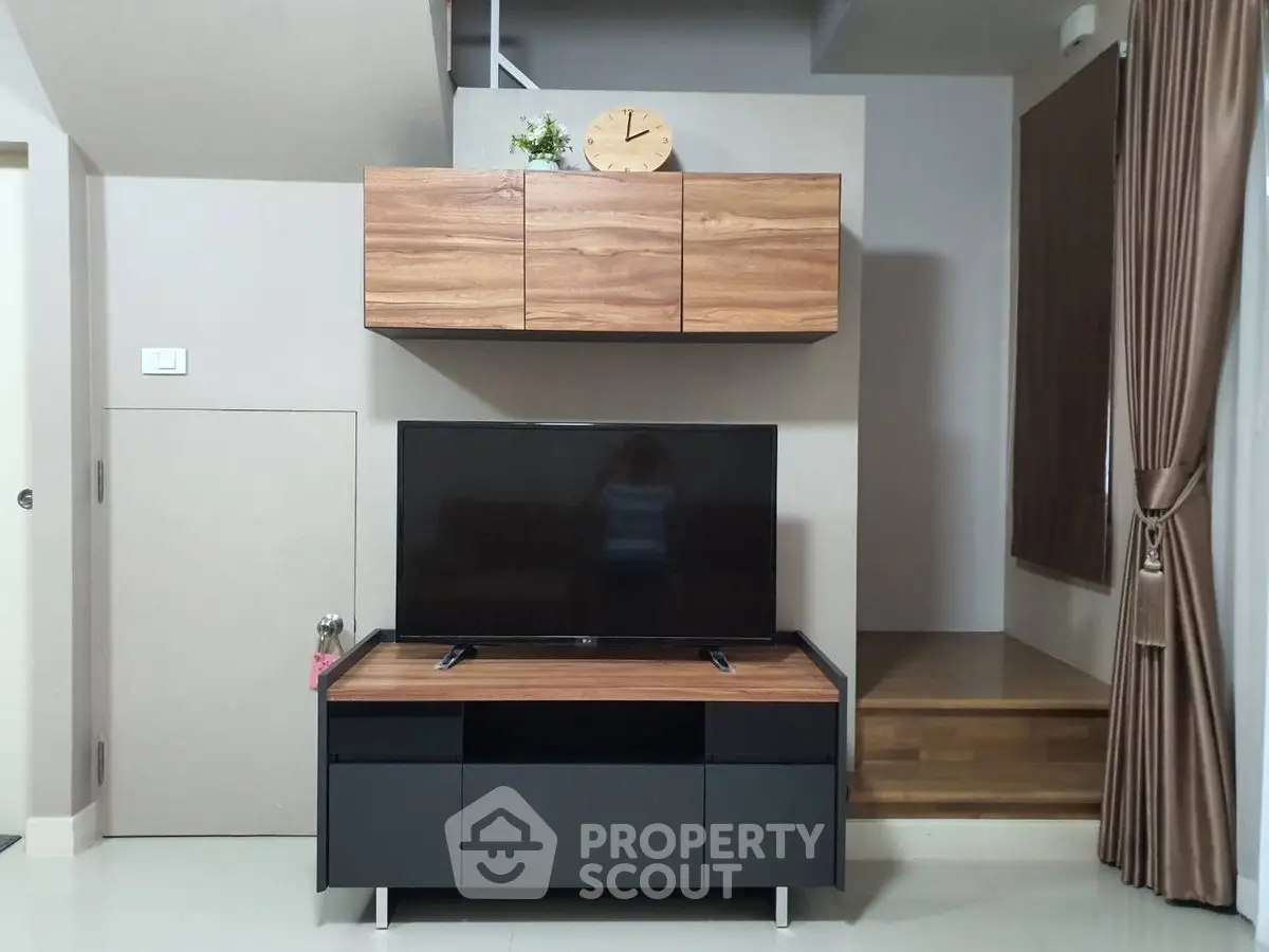 Modern living room with sleek TV stand and wooden cabinets, perfect for stylish home entertainment setup.