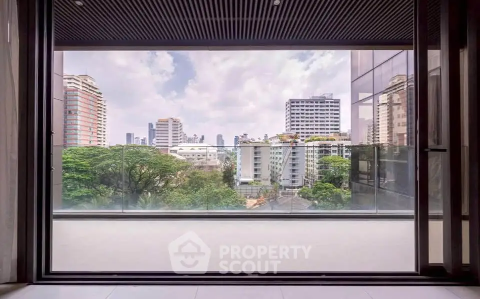 Stunning cityscape view from a modern apartment balcony with glass railing.